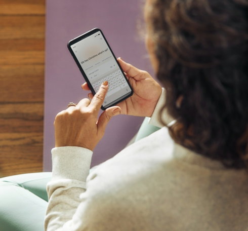 Woman using a smartphone on a yoga mat.